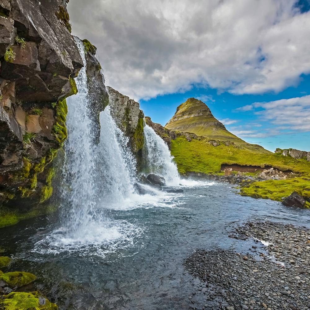Kirkjufellsfoss waterfall and Kirkjufell mountain as a backdrop