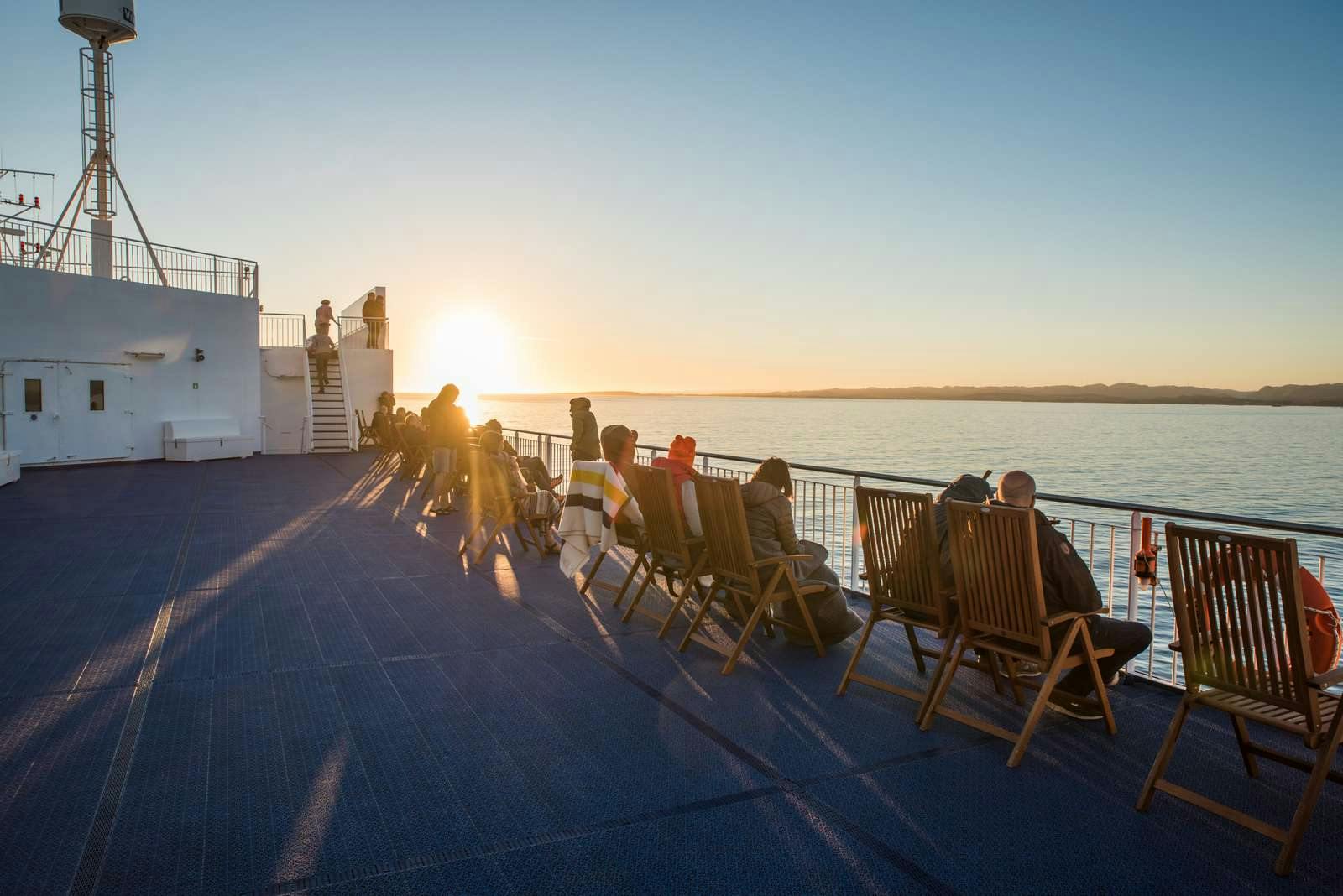 Passengers watching the midnight sun on deck of the Norröna