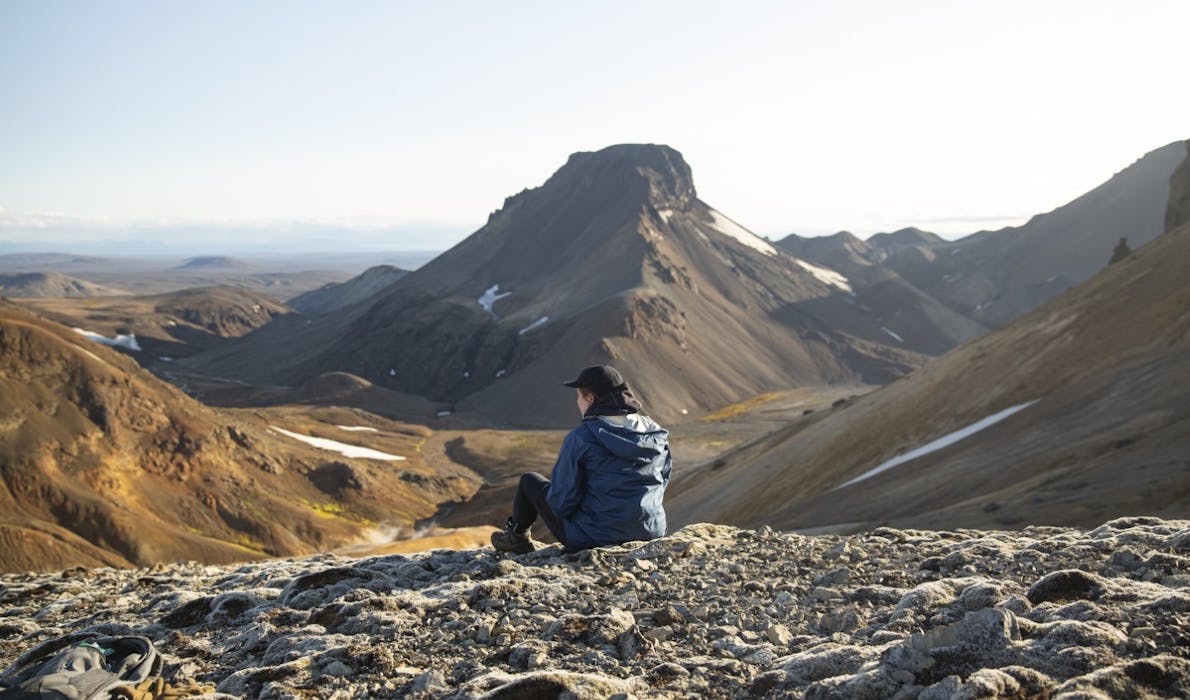 A person sitting on a mountain top in Iceland