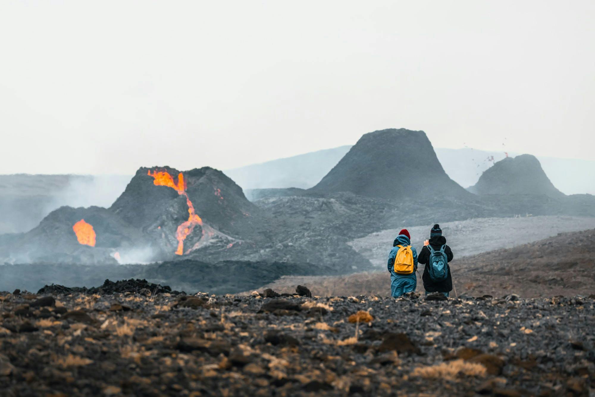 Two people admiring a row of erupting craters