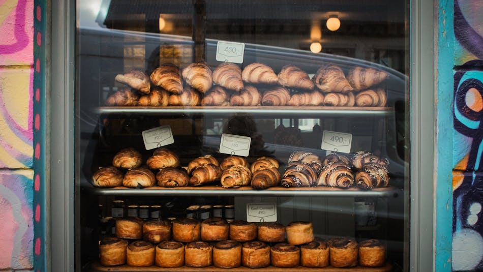 Window display of a bakery in Reykjavík filled with croissants and cinnamon buns