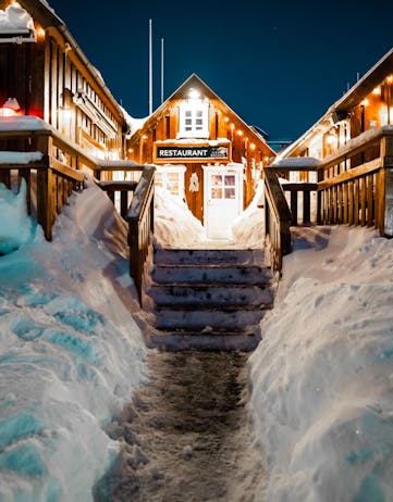 A snow path leading up to a decorated house
