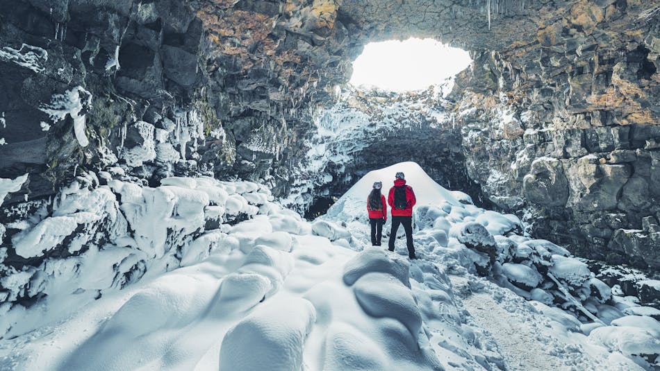 A couple viewing a cave in snow