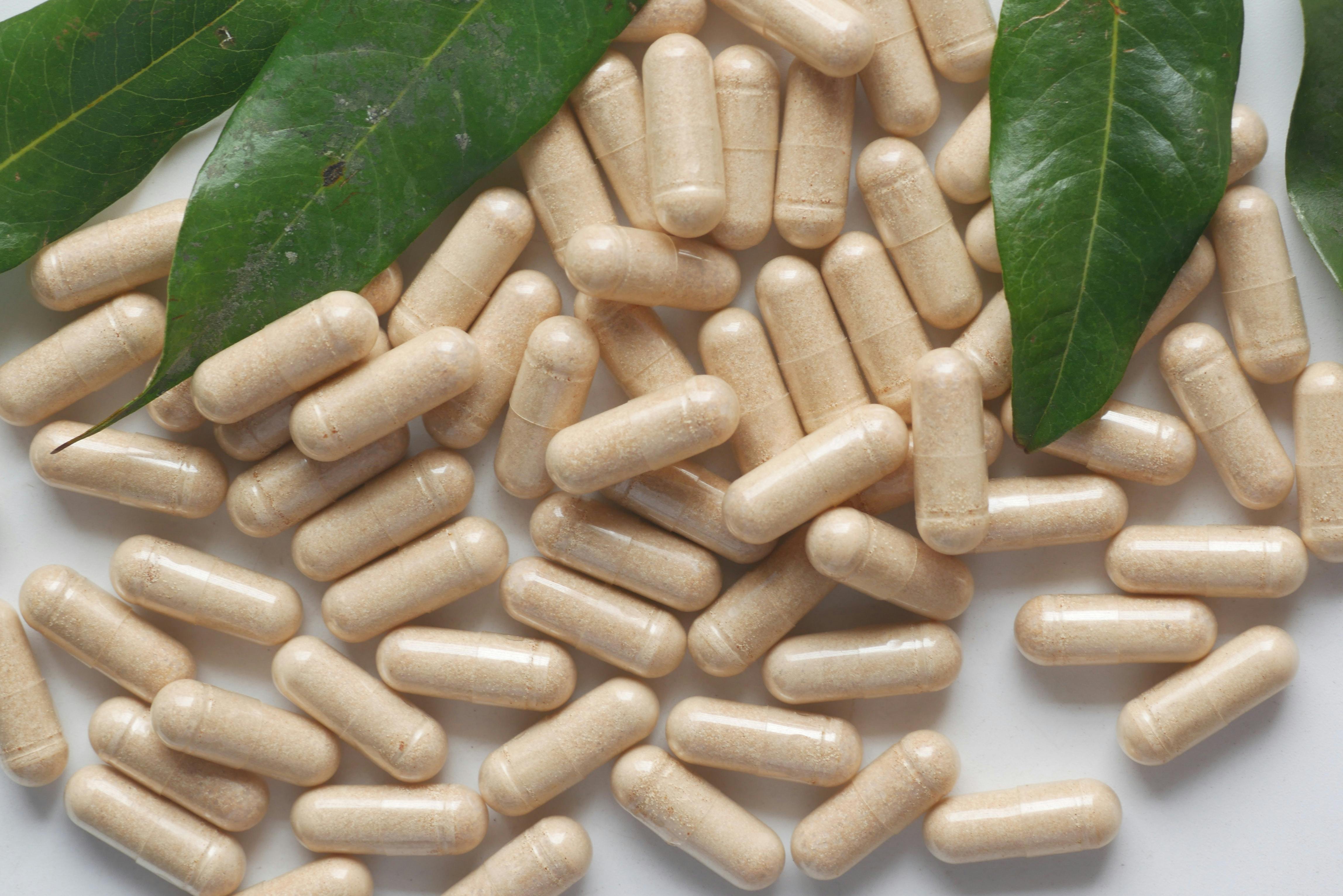 pill capsules next to some leaves