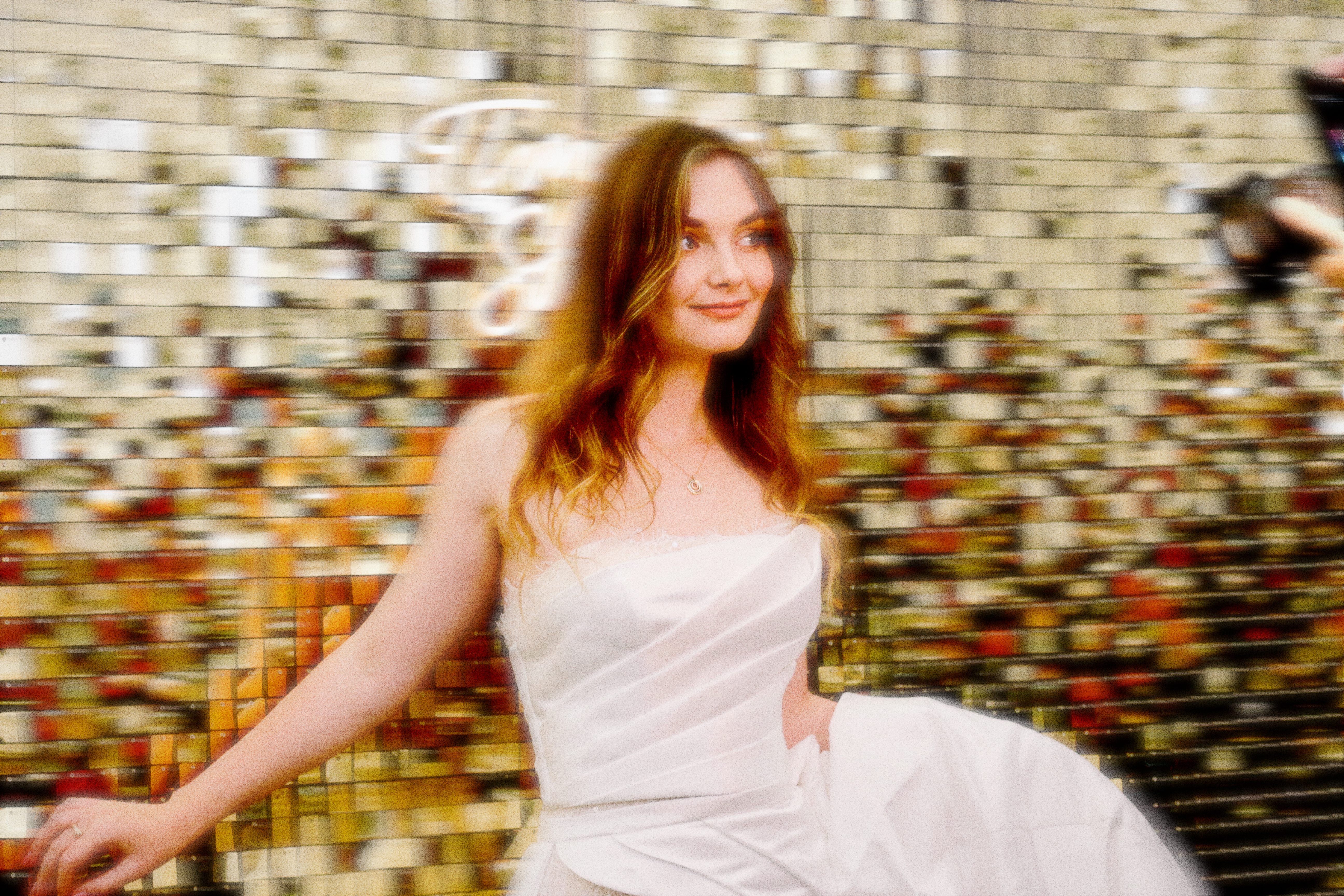 A girl posing in front of the photo booth behind a glittering gold backdrop