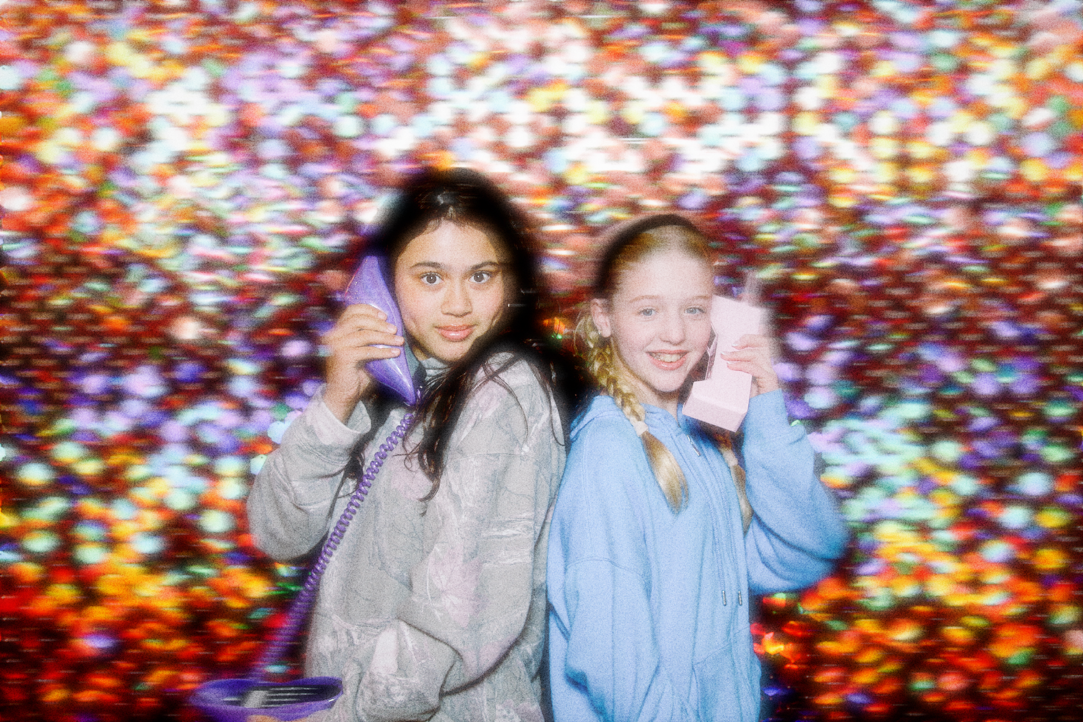 Two children having fun posing for a photo with phones for a children party