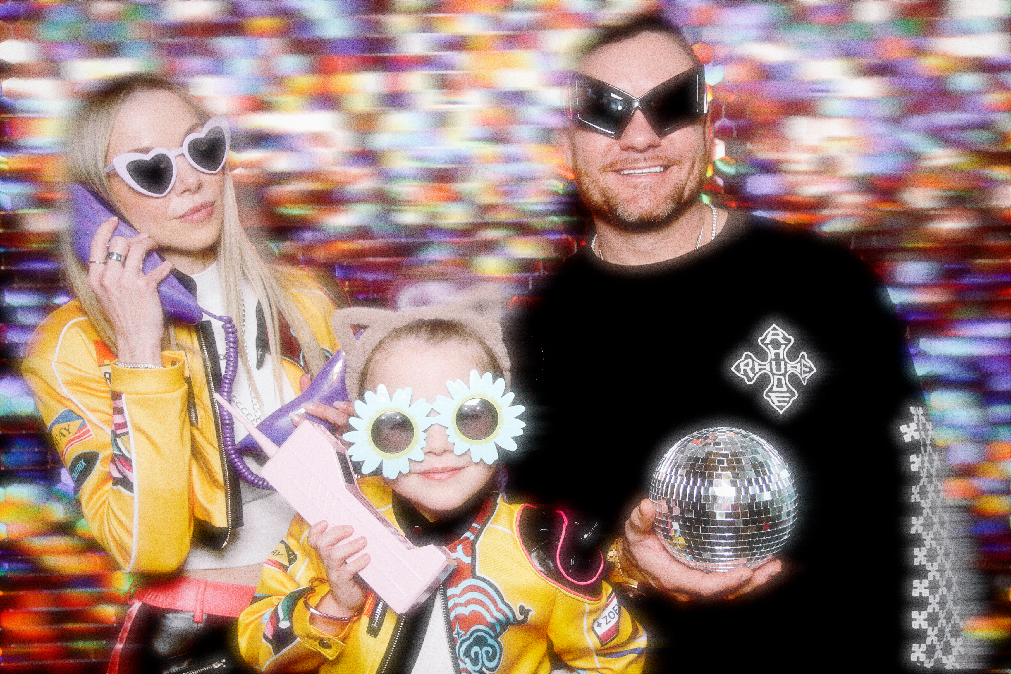 Two adults and a child having fun posing for a photo with props.