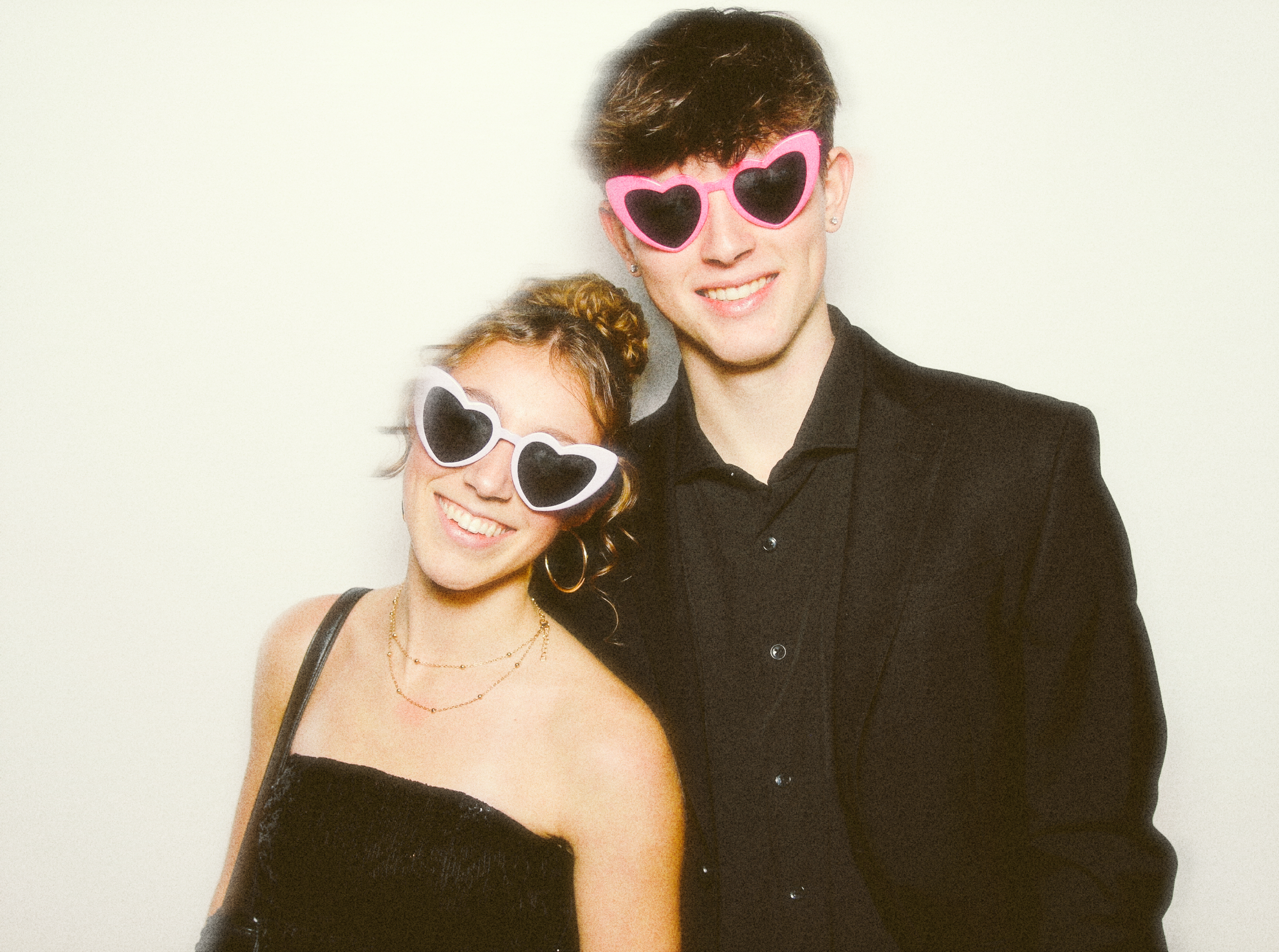 A boy and a girl posing in front of the photo booth 