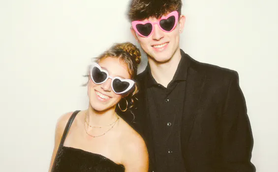 A boy and a girl posing in front of the photo booth