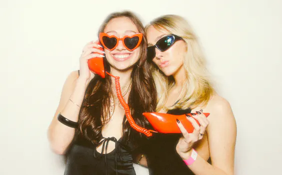 2 girls having fun posing with red accessories