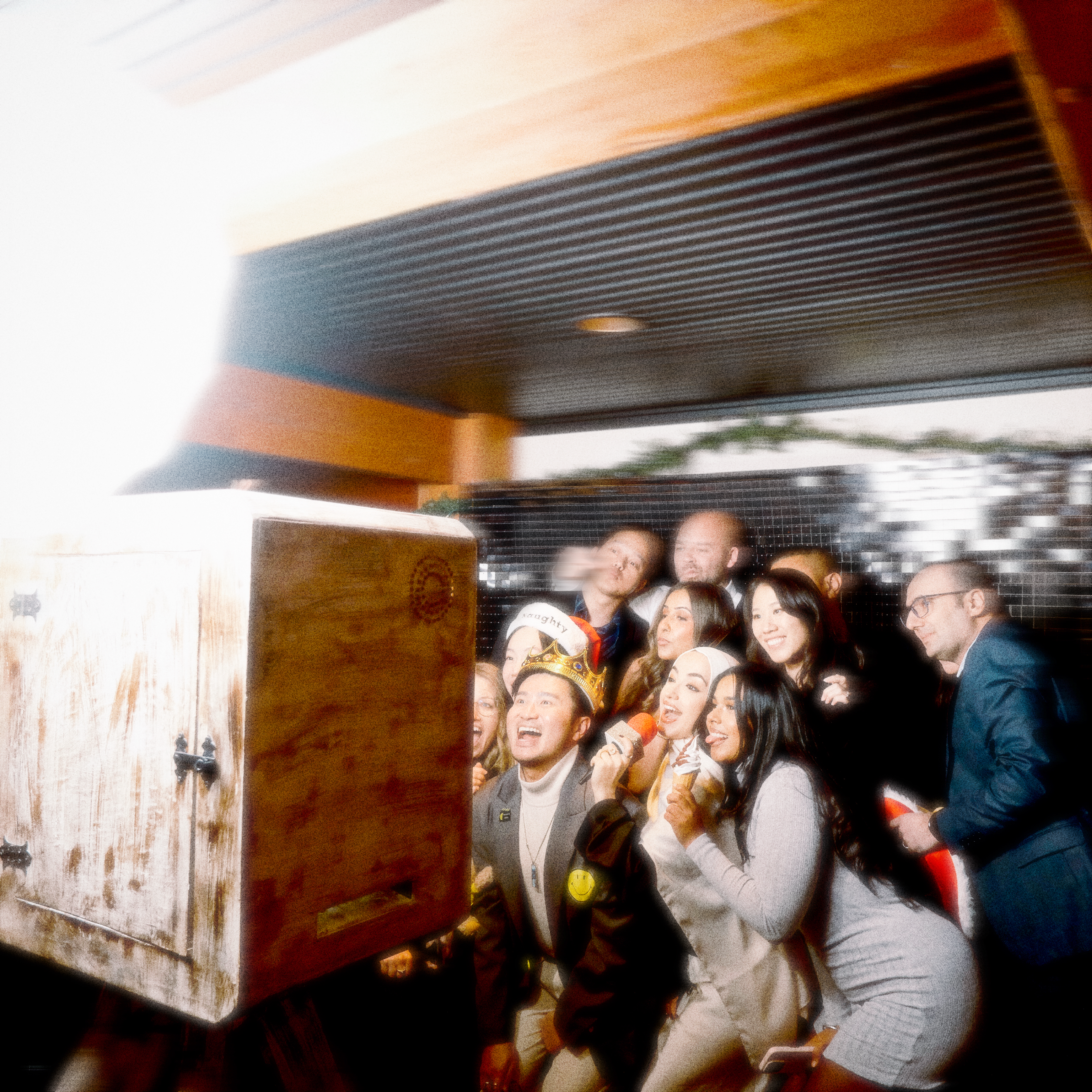 A group of colleagues posing in front of the photo booth at a corporate event