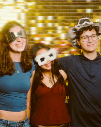 Four children and a teenager posing in front of the photo booth for a children party.