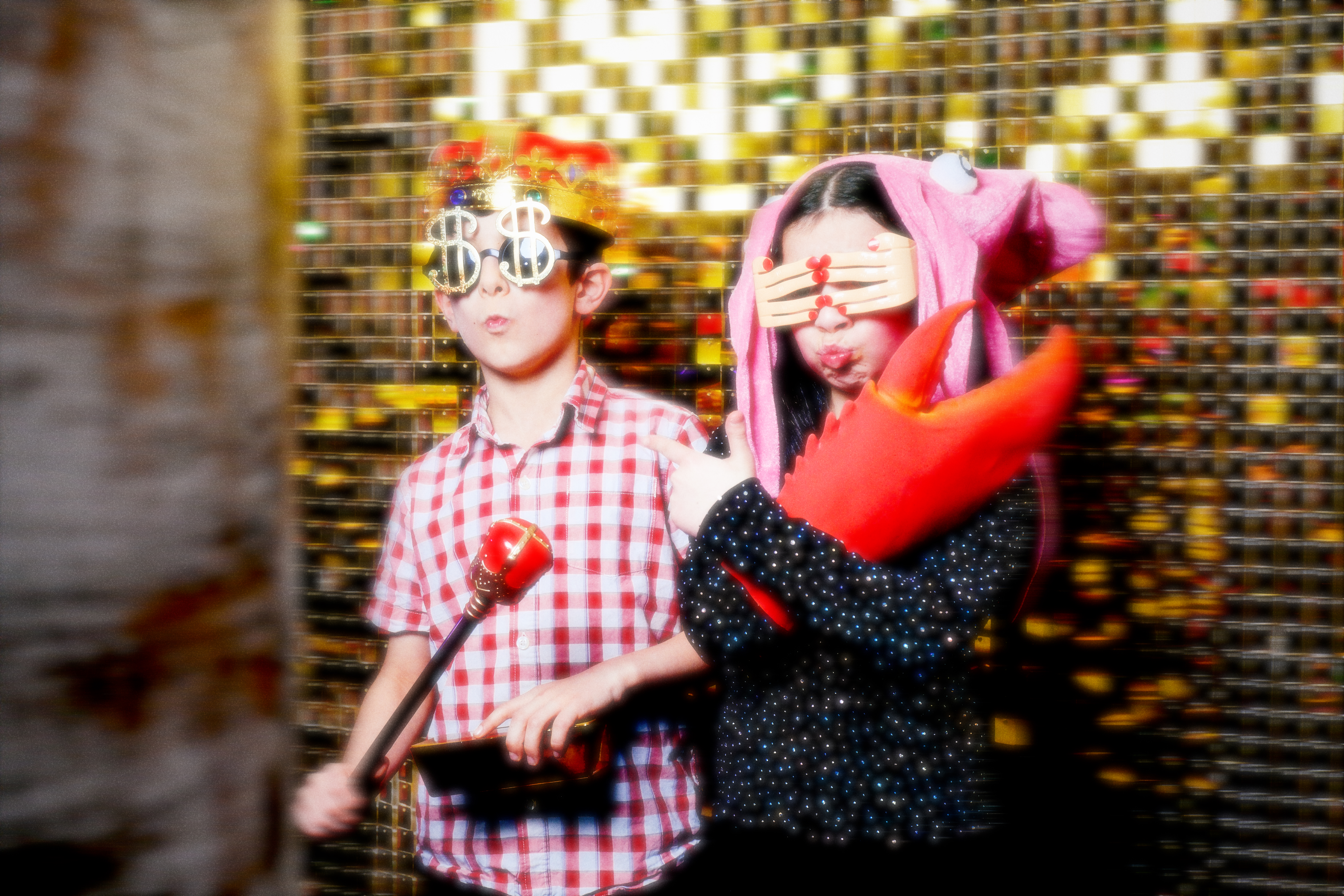 Two children in costume posing in front of the photo booth for a birthday party.