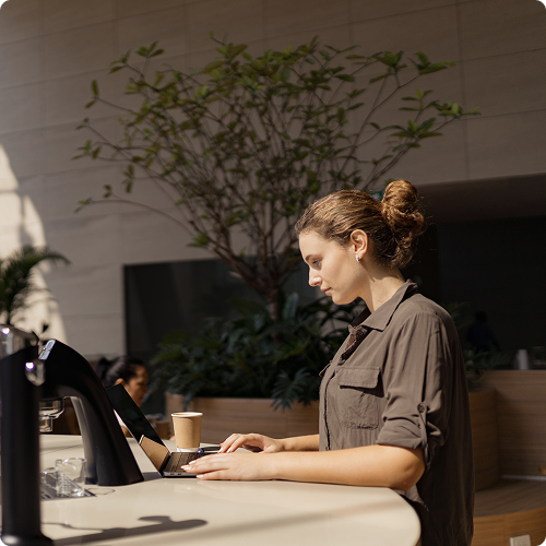 Restaurant and cafe payment solutions — barista managing orders and payments on a laptop at a sunny outdoor counter, viva.com payments for modern food service