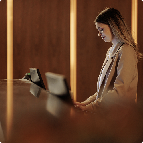 Hotel payment solutions at every guest touchpoint — front desk receptionist processing a payment on a POS terminal, viva.com hospitality payments- seo optimised