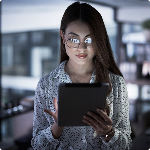 Professional woman with glasses reviewing her business account on a tablet in a modern office, representing digital business account management with viva.com