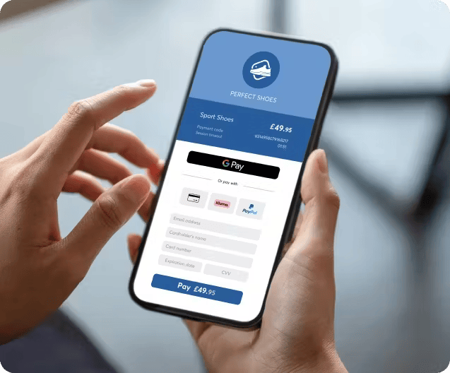 Hands holding smartphone displaying Viva.com Smart Checkout payment screen for Perfect Shoes showing £49.95 total with Google Pay, card, and PayPal payment options