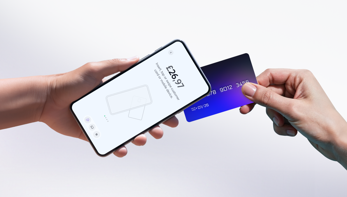 Hand holding smartphone displaying £26.91 payment request with card reader icon while another hand presents blue gradient payment card for tap payment