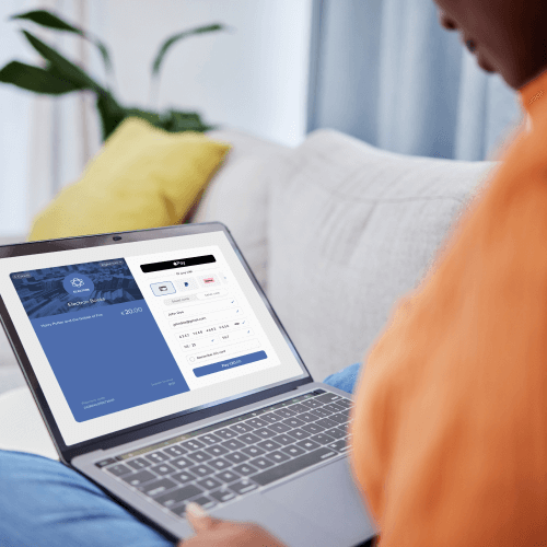 Person completing online payment on secure checkout page using laptop.