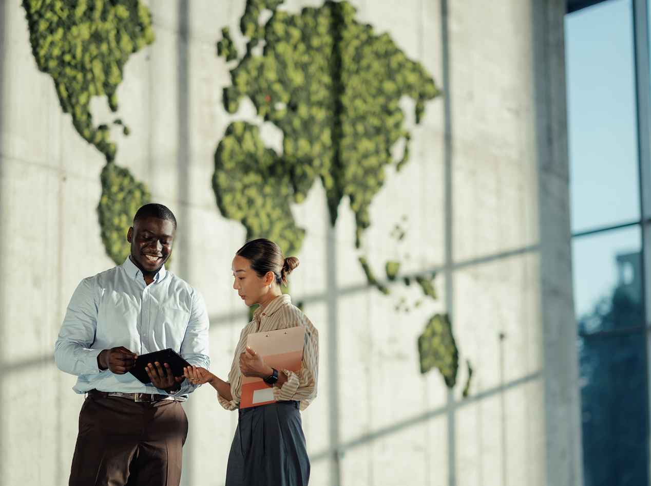 ISV payment partner for European market expansion — two business professionals reviewing a tablet in front of a world map, viva.com single integration across 29 European markets