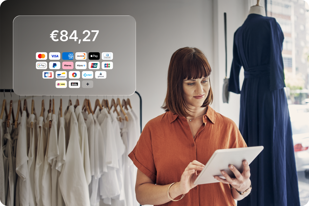 Retail business owner using a tablet to accept payments, with multiple payment methods including Mastercard, Visa, Apple Pay, Google Pay, Klarna and more
