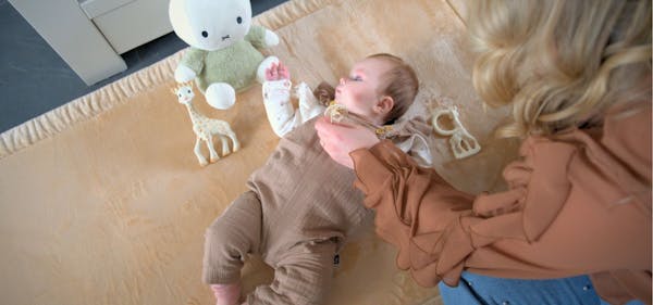 Baby ligt op speelkleed