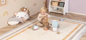 Vloerkleed in een ingerichte kinderkamer met zachte kleuren