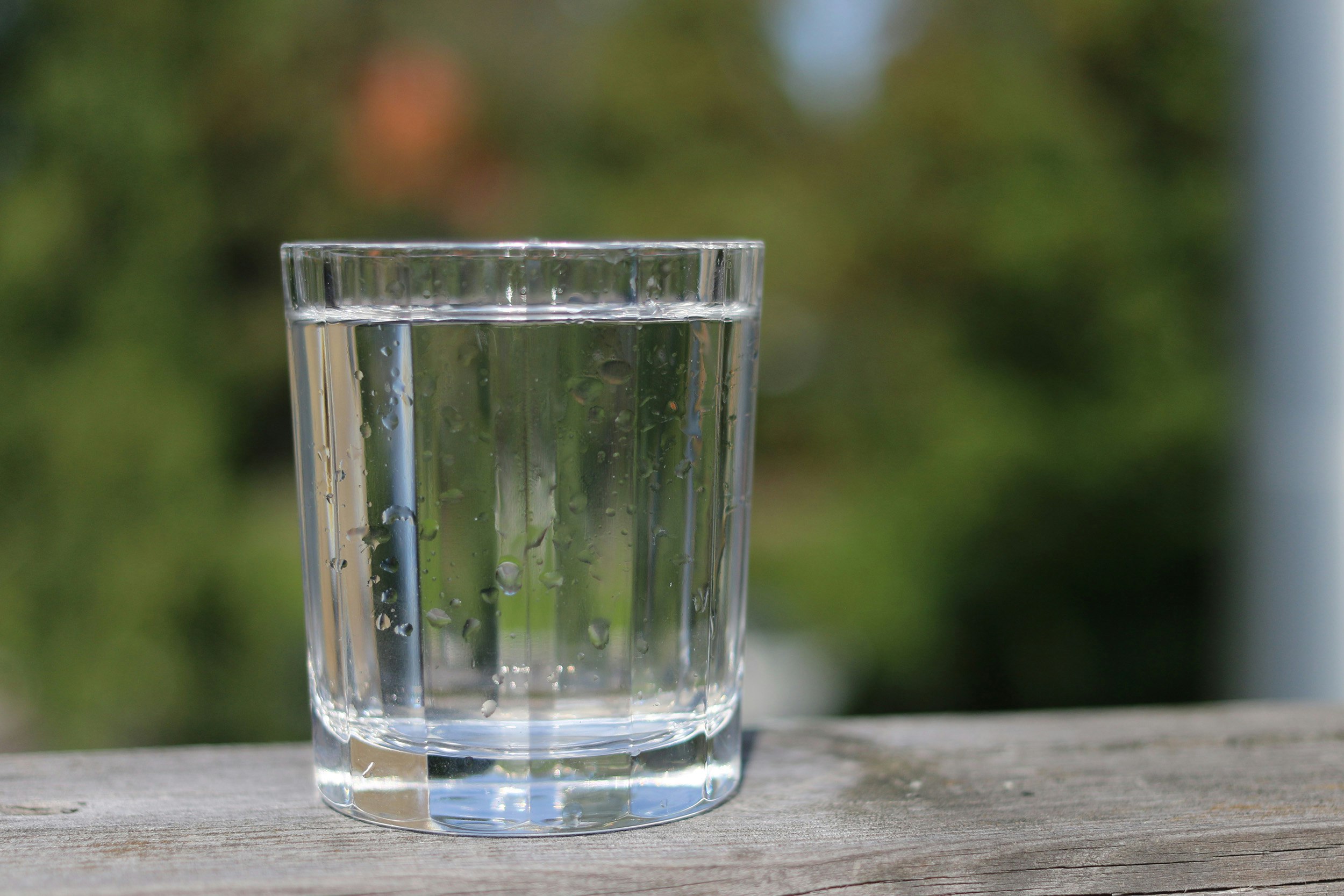 Glas med vatten på träskiva