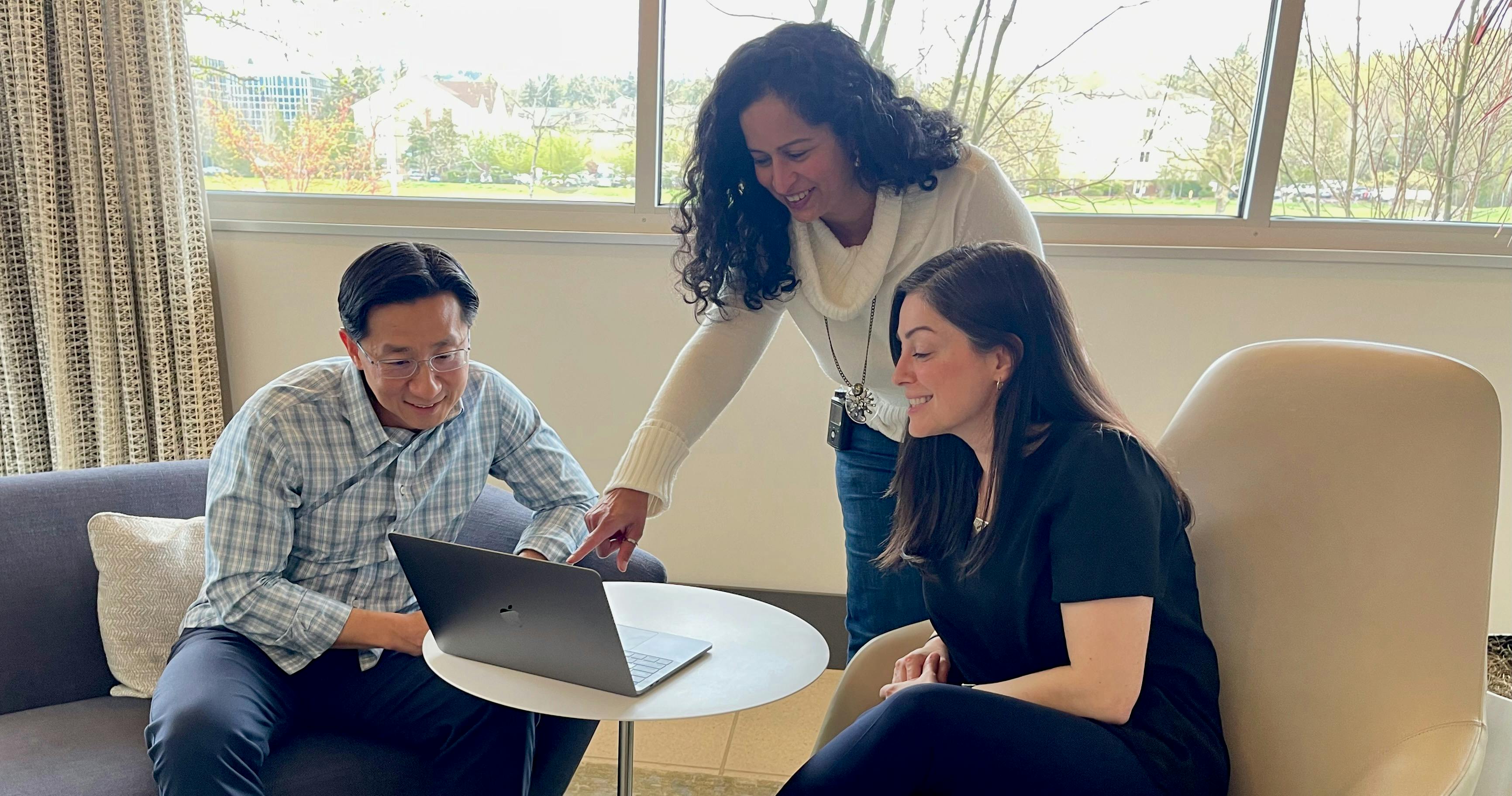 Andy sitting down with small group around laptop (Image courtesy Providence)