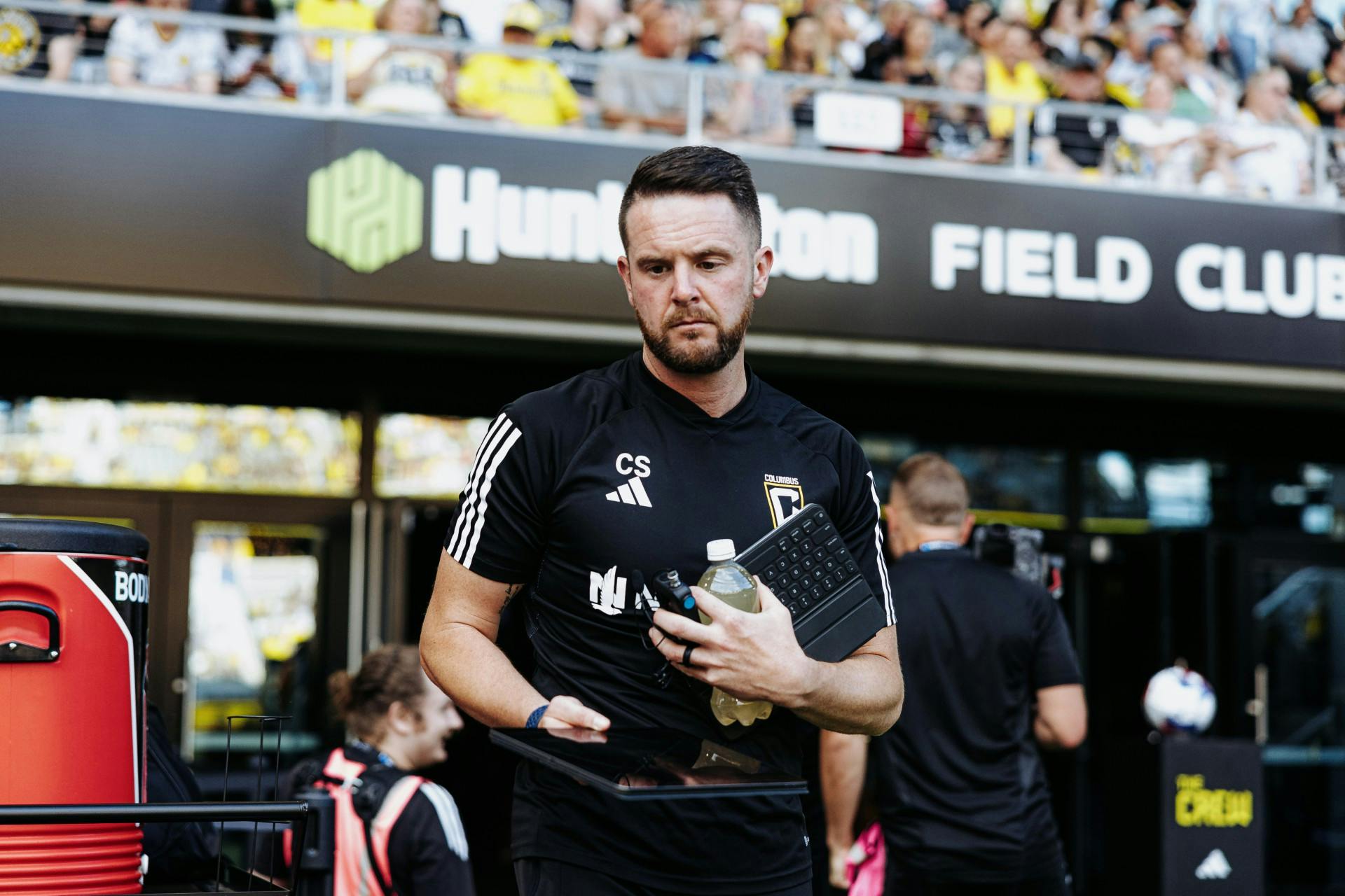 Chris walking onto pitch with iPad and keyboard in hand (photo courtesy Columbus Crew)