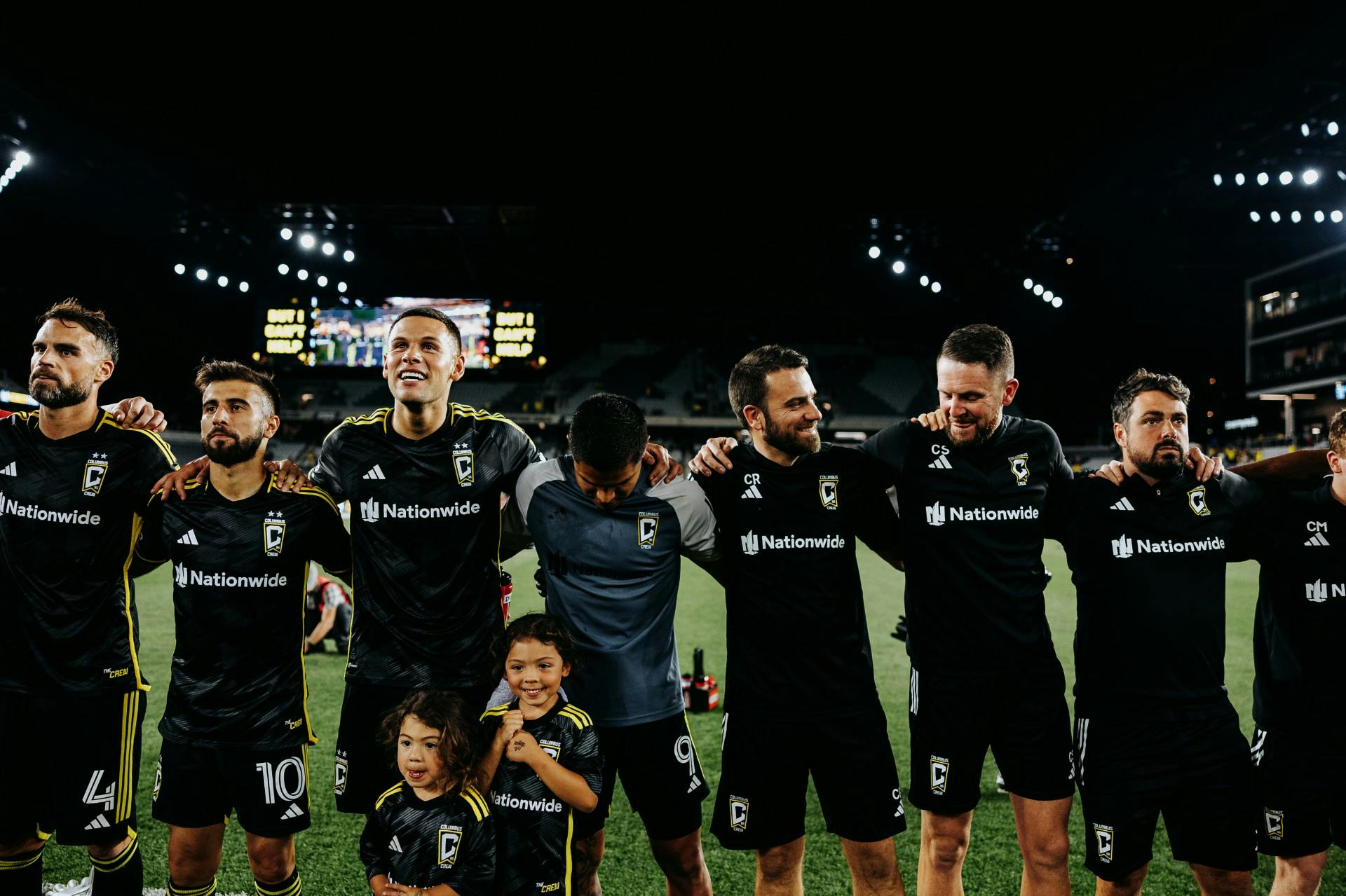 Chris standing shoulder to shoulder with teammates on pitch (photo courtesy Columbus Crew)