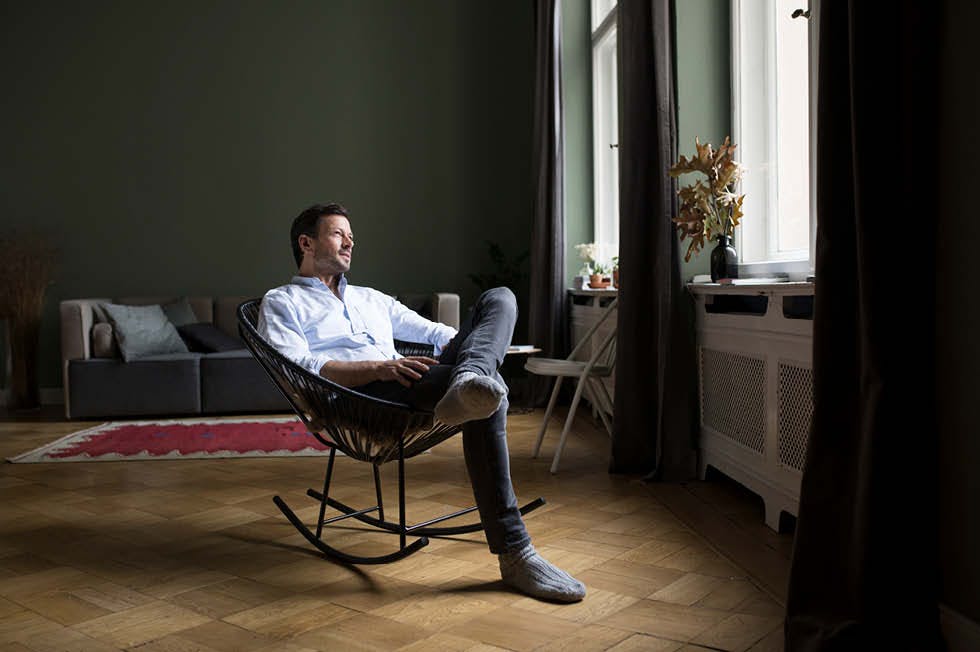 Man looking out the window sitting on his rocking chair