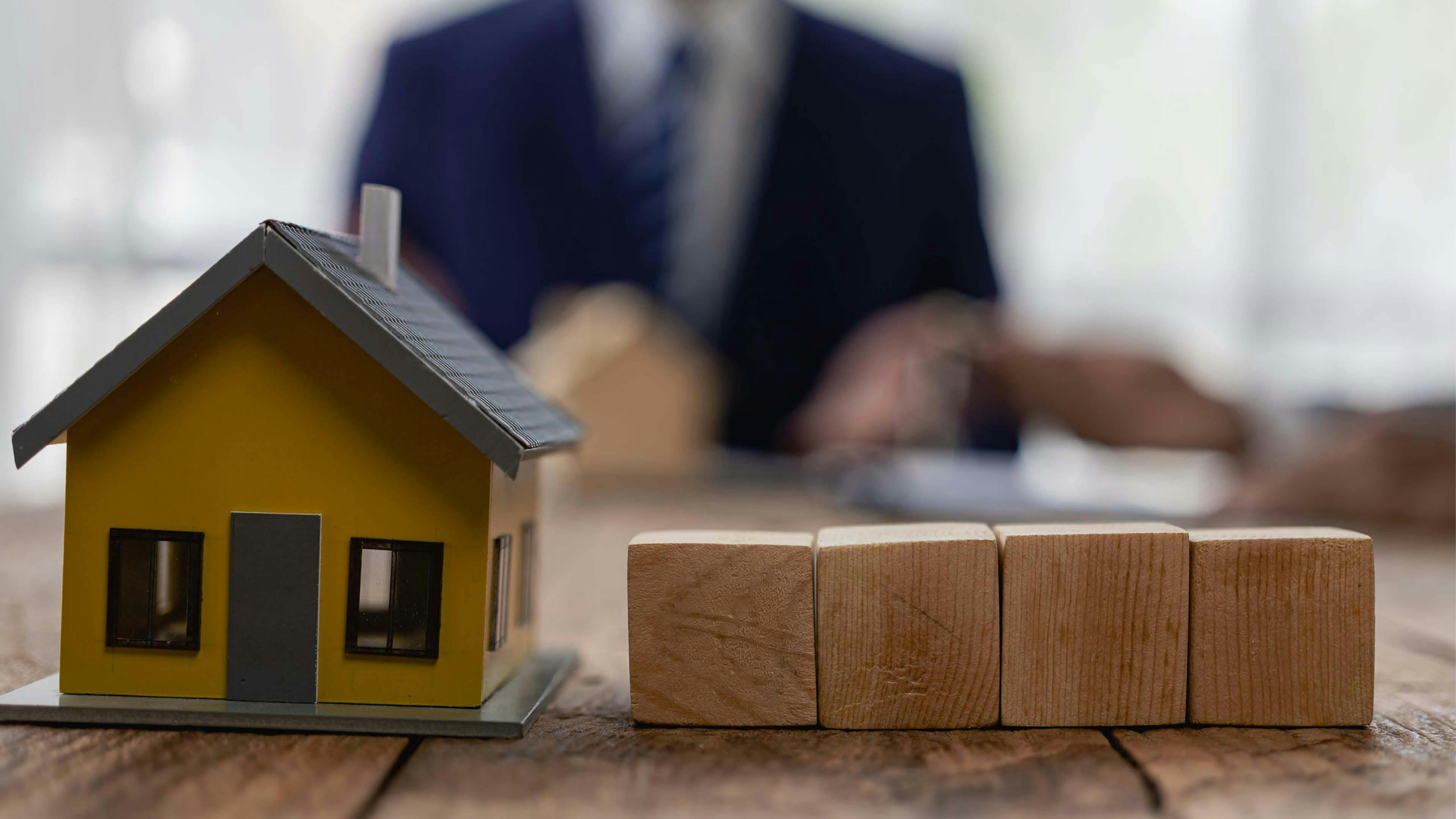 Toy blocks in focus, realtor in the background