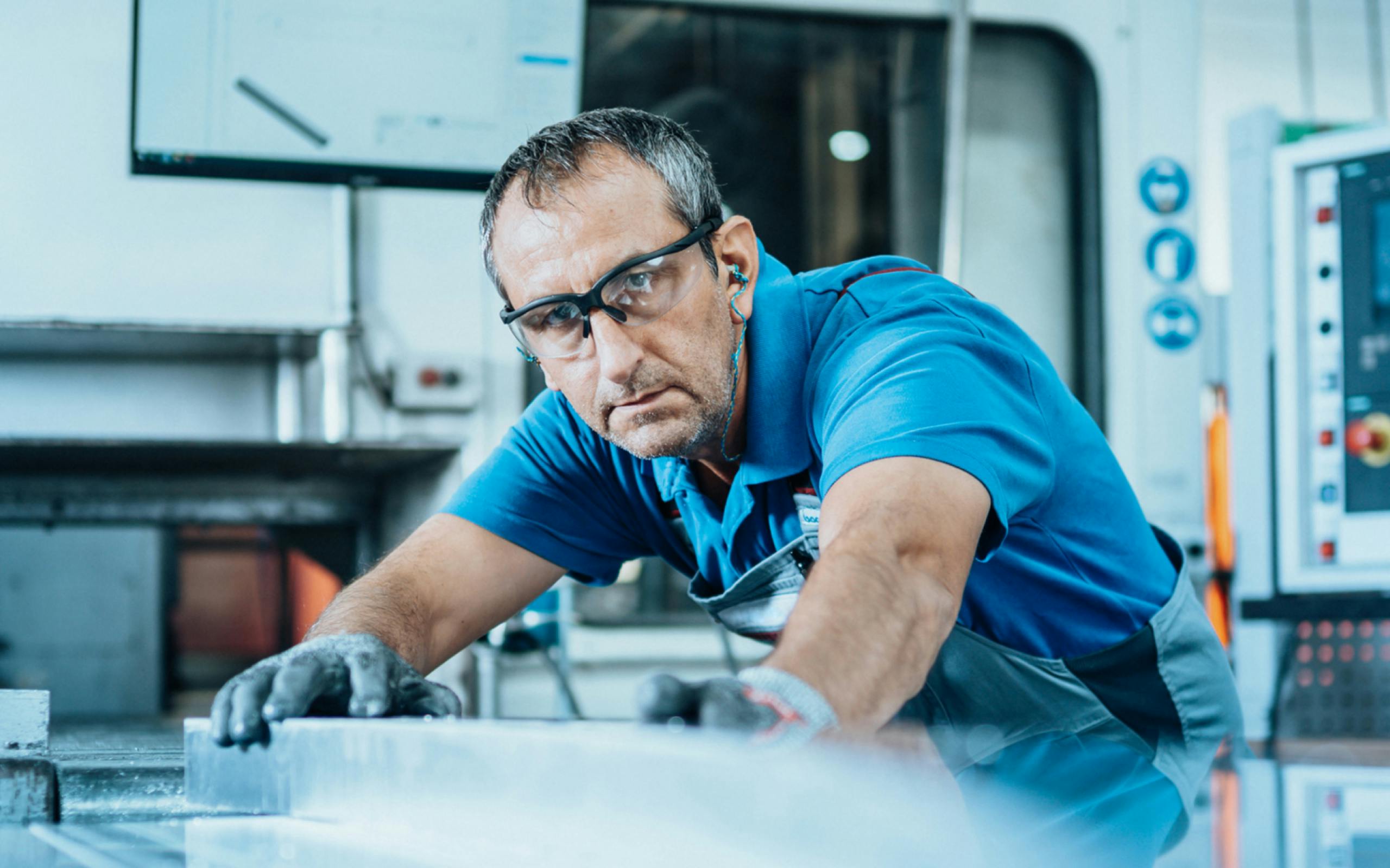 SCA Coverbild zeigt einen Mitarbeitenden in der Produktion mit Schutzkleidung. In der linken oberen Ecke befindet sich das SCA Logo