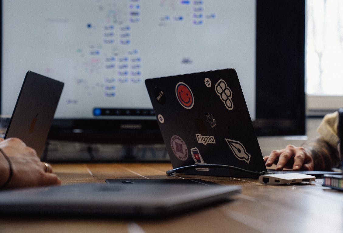 Momentaufnahme bei einem Teammeeting; Laptop mit Werk 8-Aufklebern