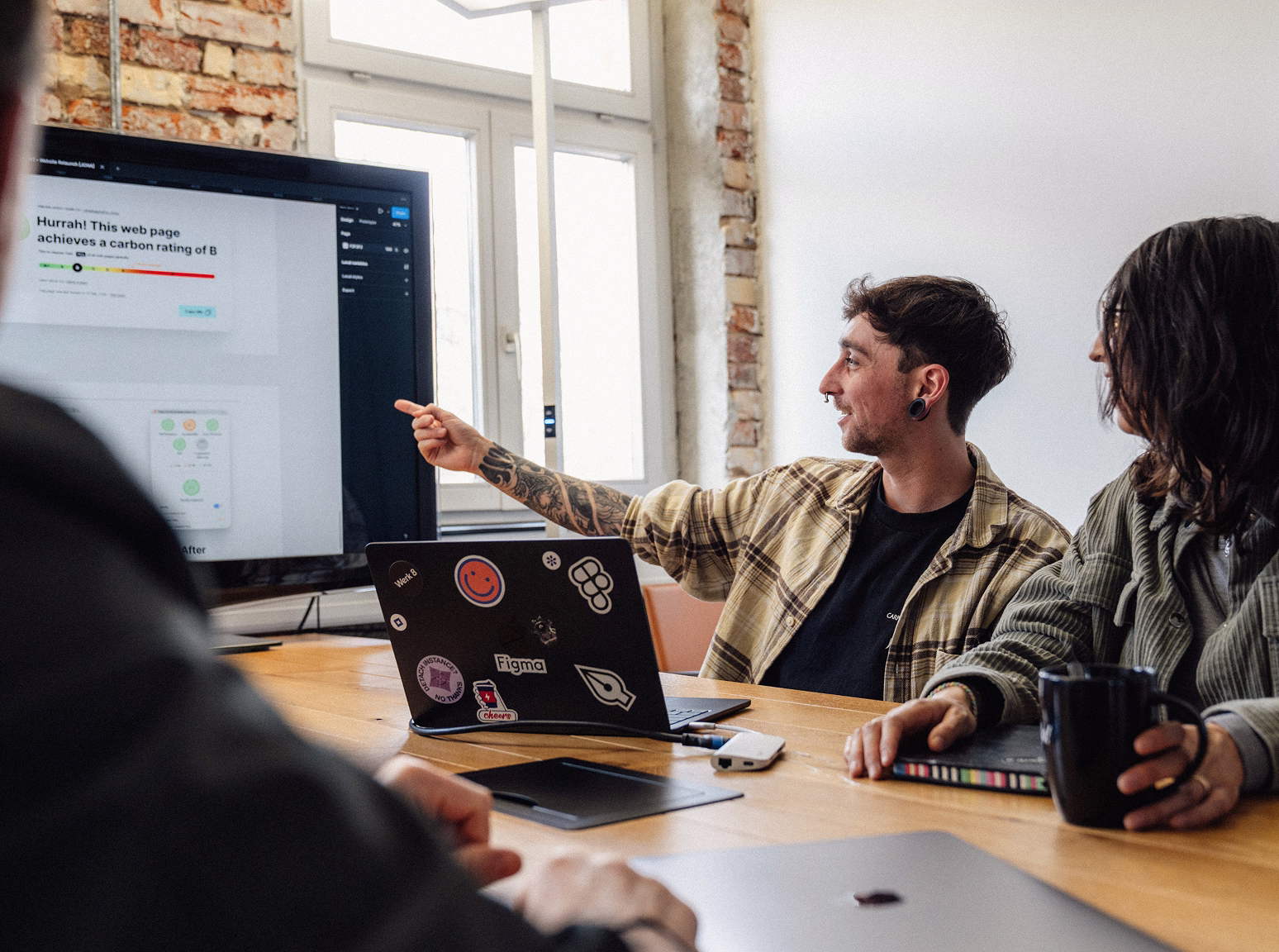 Teammitglied von Werk 8 (Nils Salzer) zeigt auf Bildschirm in einem Meetingraum.