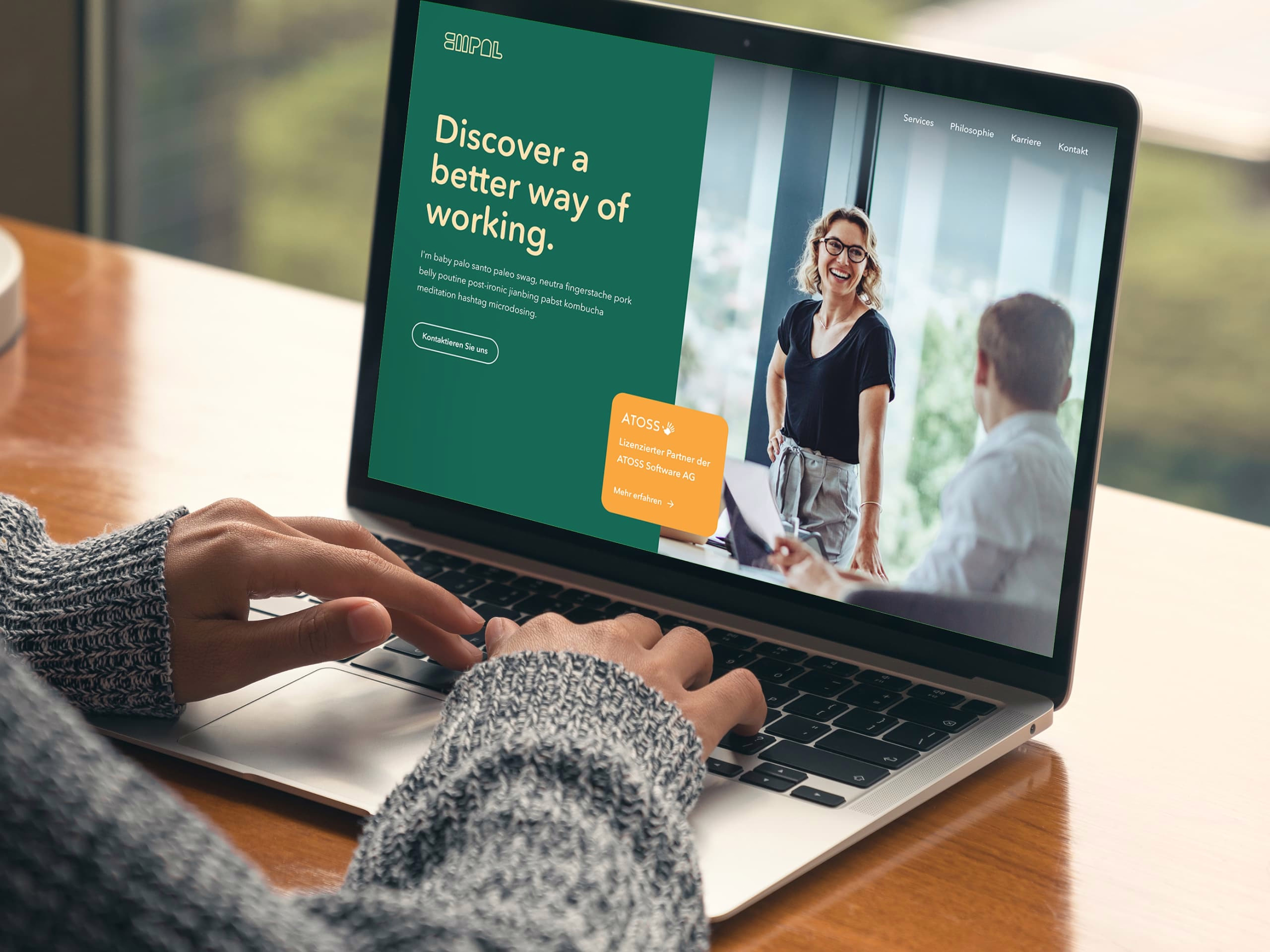 Mock Up eines Laptops, zu sehen ist die Startseite von Empal mit dem Slogan "Discover a better way of working" neben einer Abbildung, auf der die Mitarbeitenden von Empal zu sehen sind