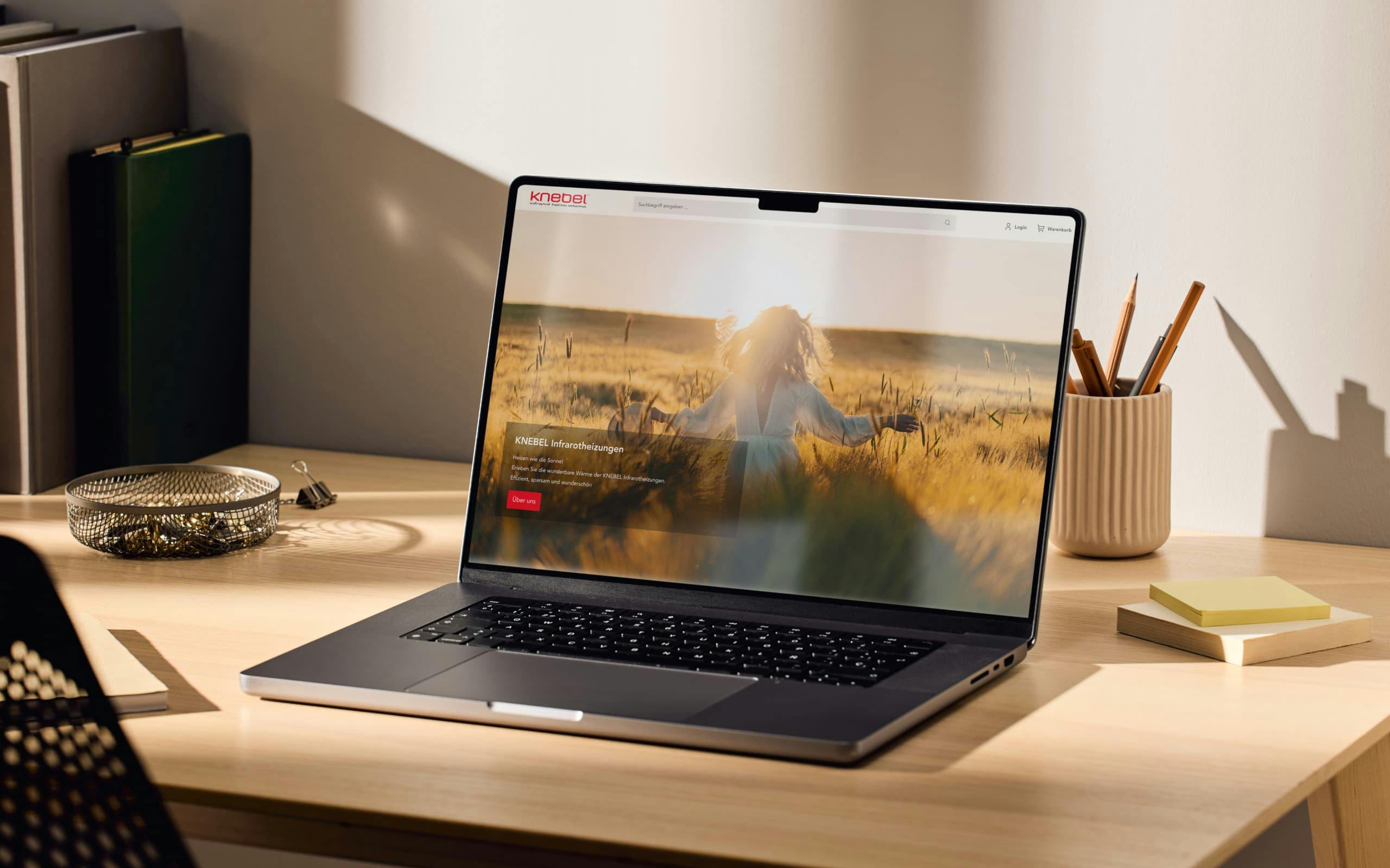 Laptop auf Schreibtisch, auf dem die Startseite von Knebel zu sehen ist.
