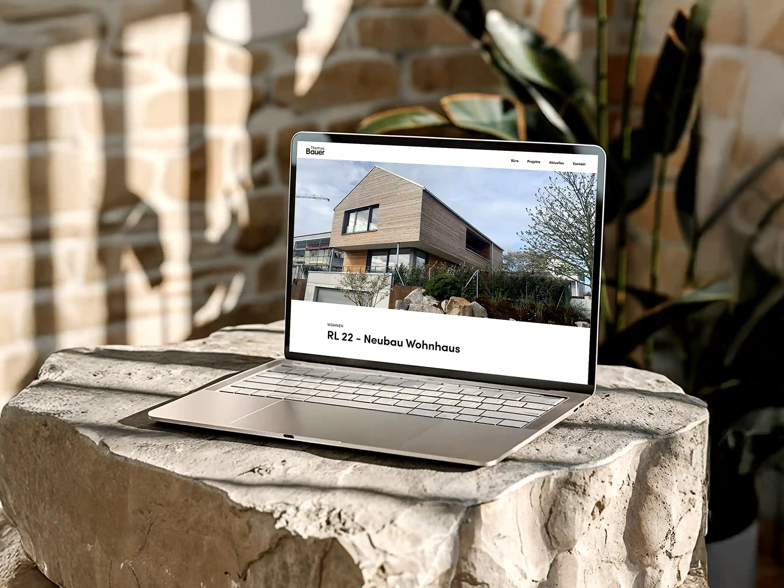 Laptop auf Steinblock mit Ansicht eines Projekts des Architekten Thomas Bauer aus Flein umgesetzt von Werk 8