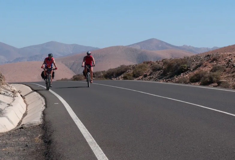 two cyclists on the scenic road from Pajara to the west coast of the island, Fuerteventura