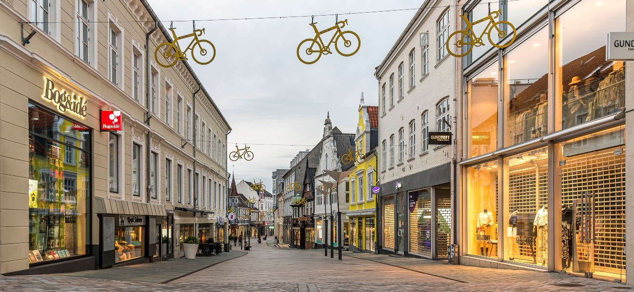 bike logos for Tour de France hanging in the soft evening light over the shopping street in Vejle, Denmark