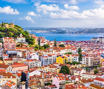 The colorful houses of Lissabon in Portugal with the blue skies and sea in the background