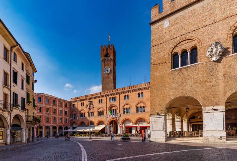 View of Piazza dei Signori (Lord's Square) and Palazzo dei Trecento with Tower Clock on a sunny day