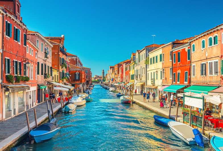 island, bridge across water canal, boats, motor boats, colorful traditional buildings, Venetian Lagoon, Veneto Region, San Michele in Isola Catholic church