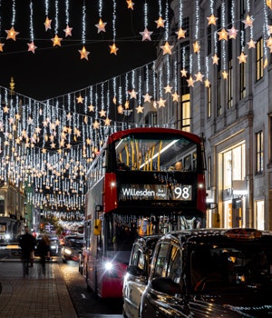 Christmas decorations hanging over a shopping street in London at night