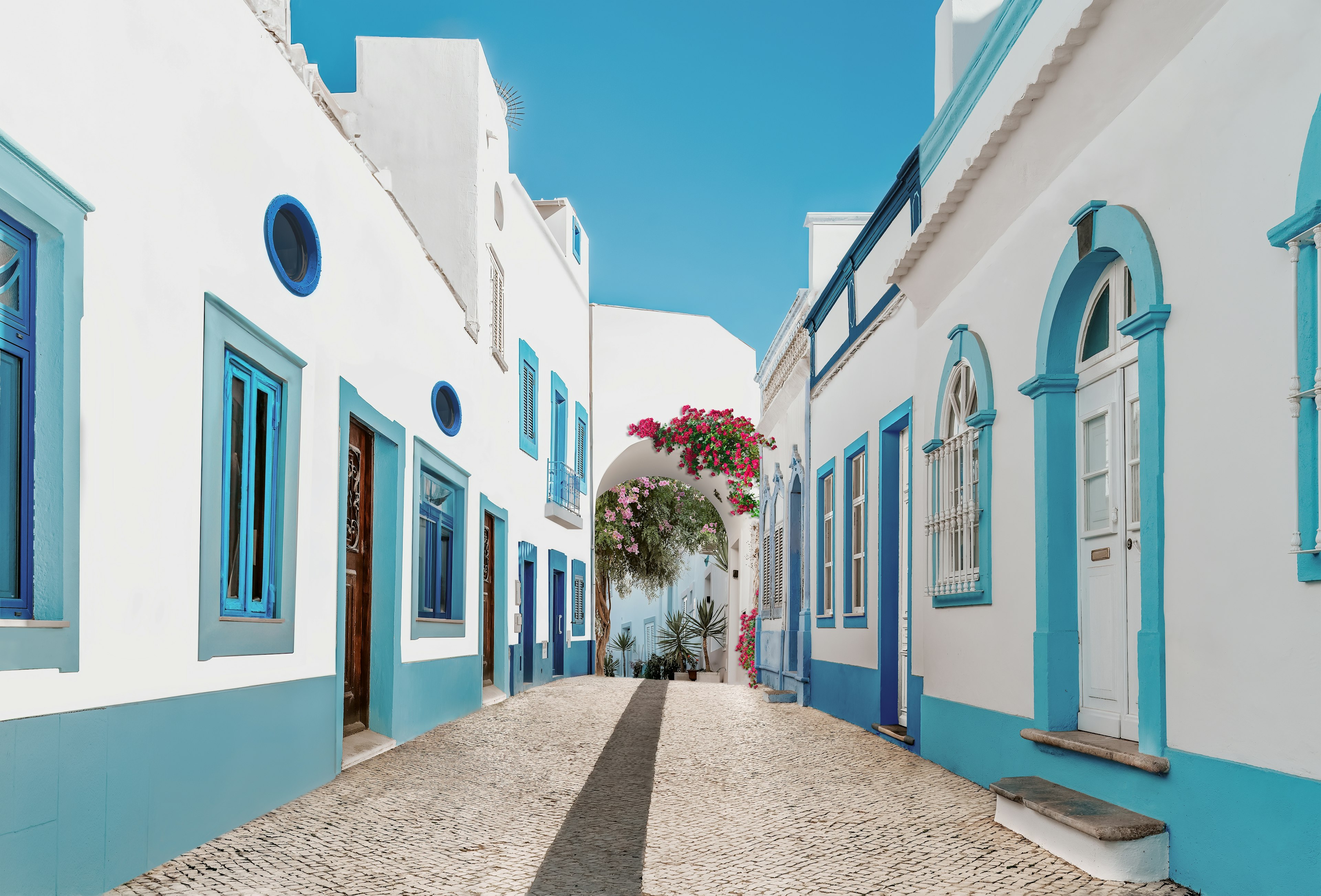 White and blue houses in a street in Olhao, Algarve in Portugal.