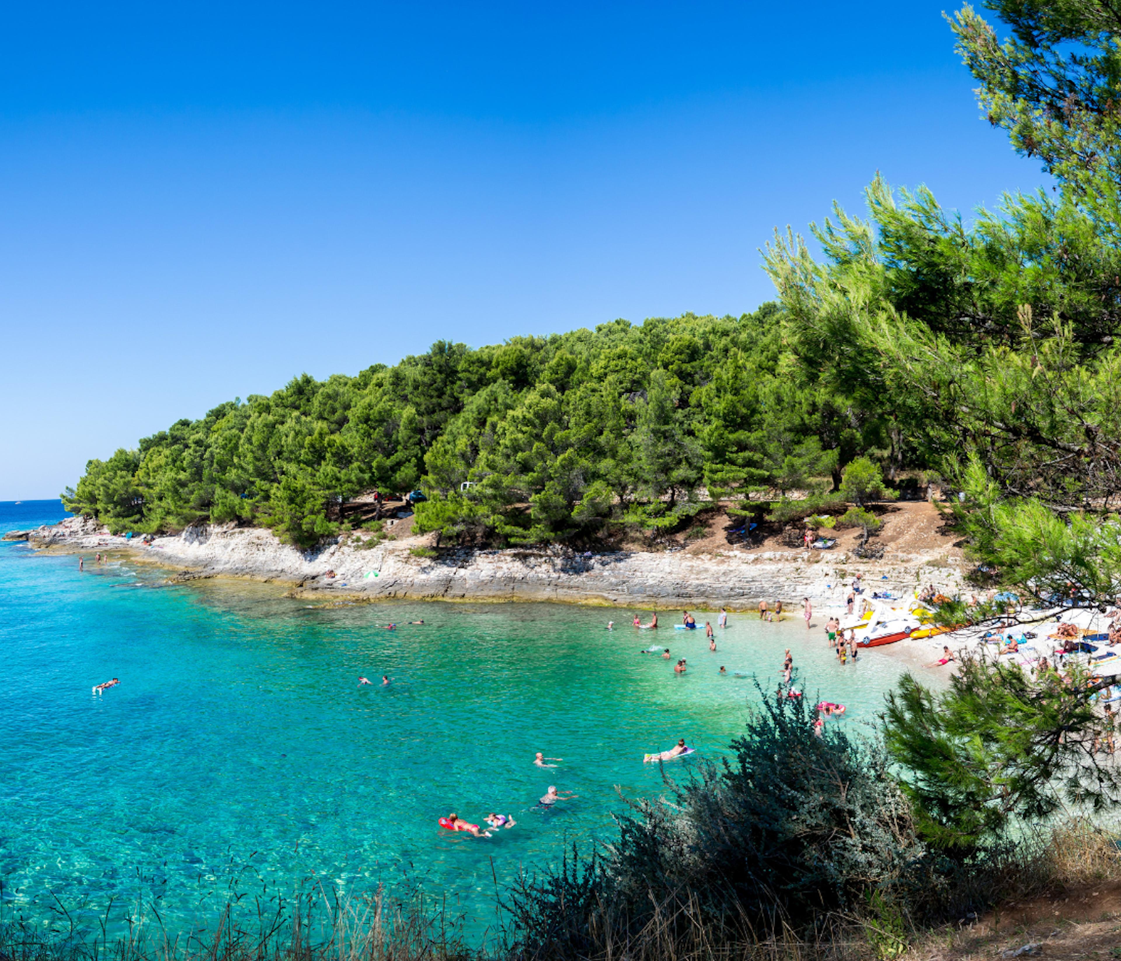 People enjoying a charming beach in beautiful coastal Pula city in Croatia