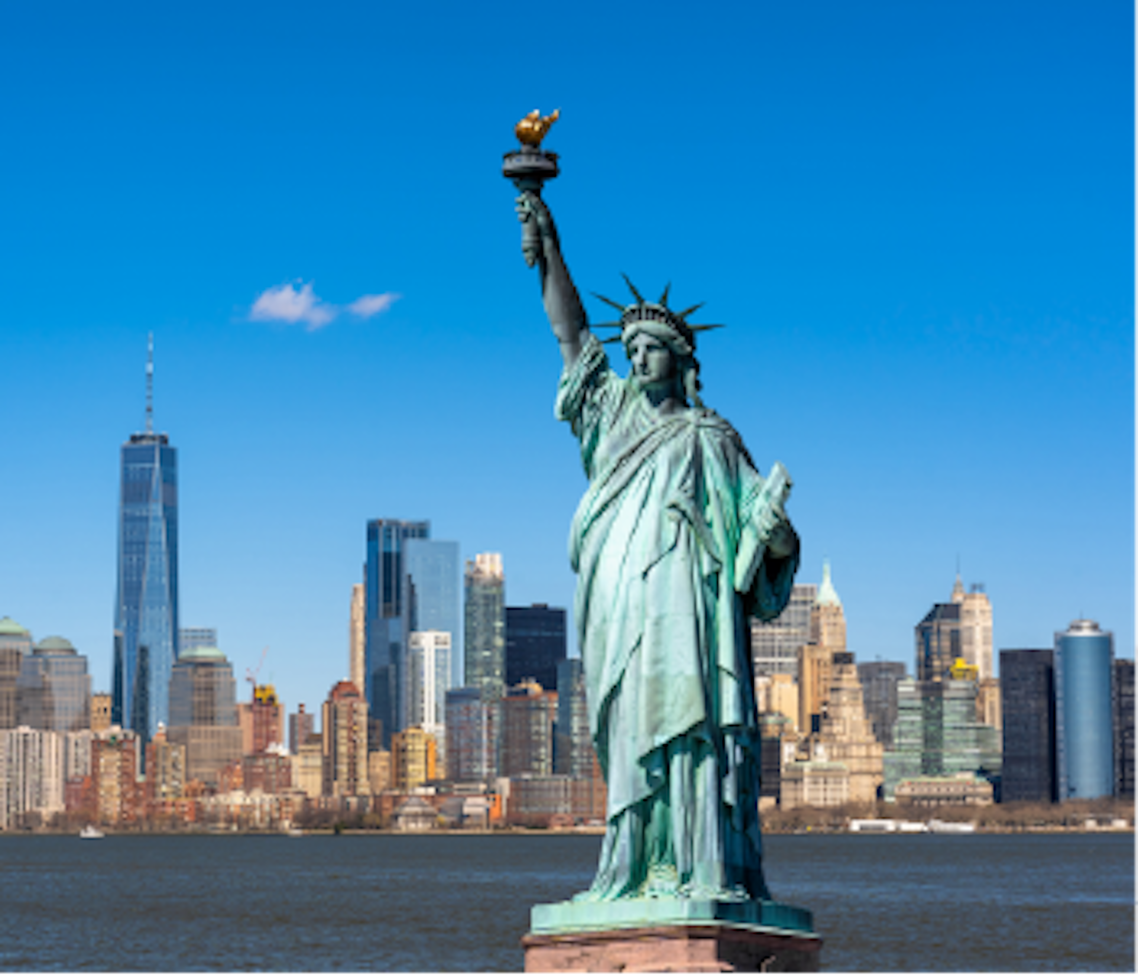 Statue of liberty in New York city with Manhattan in the background with clear blue sky