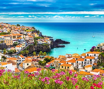 Blue sky, blue ocean and a hillside with beautiful buildings in Madeira