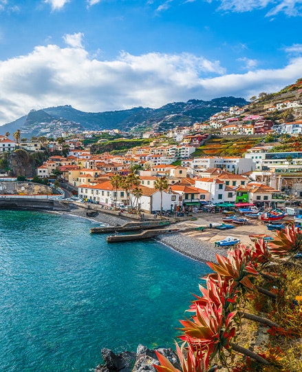 Blue sky and ocean and a hillside with beautiful buildings in Madeira